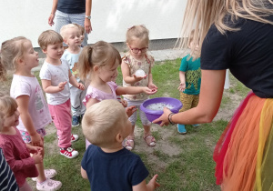 Zuzieńka trzyma magiczną bańkę mydlaną z zawartym w niej dymkiem. Wokół są obserwujące dzieci.